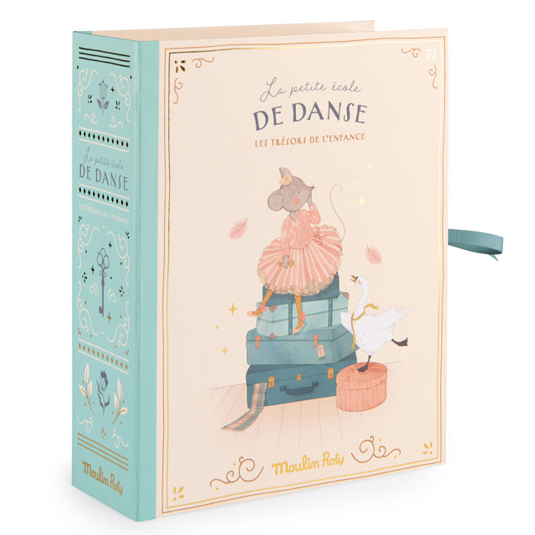 Gesloten Moulin Roty geboortedoos in de vorm van een boek, met een illustratie van een dansende muis op koffers.
