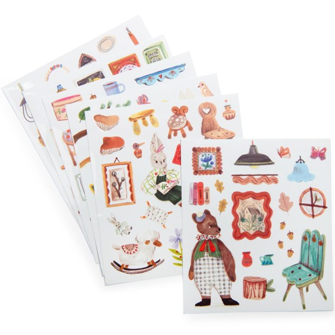 Meerdere vellen met kleurrijke stickers van figuren, meubels en decoratieve items.