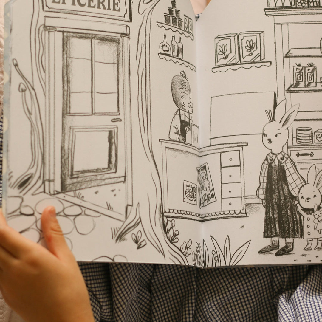 Detail van een open pagina van het kleur- en stickerboek met een zwart-wit illustratie van konijnen in een winkel.