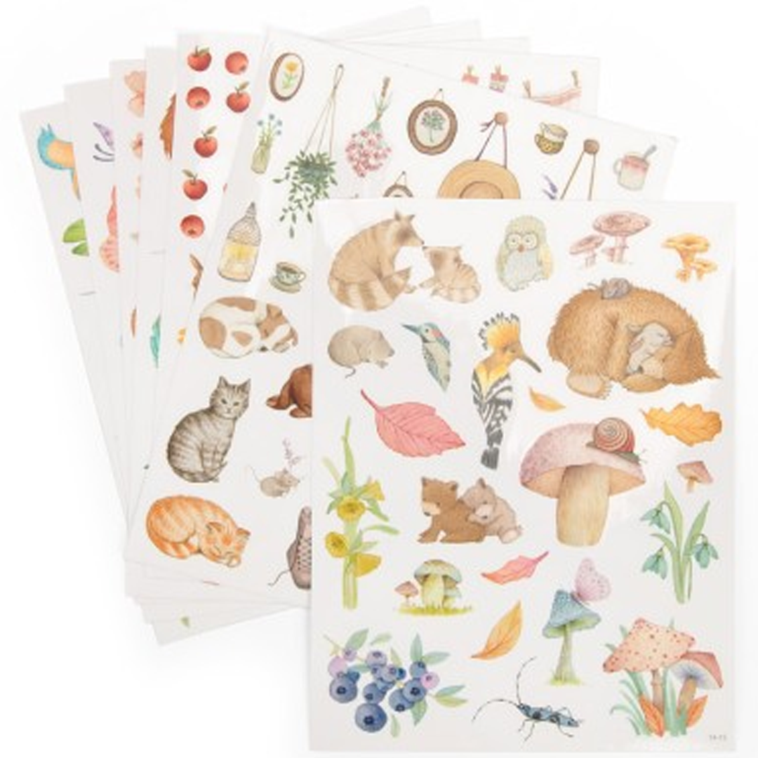 Een stapel sticker vellen met illustraties van diverse dieren, paddenstoelen en planten.
