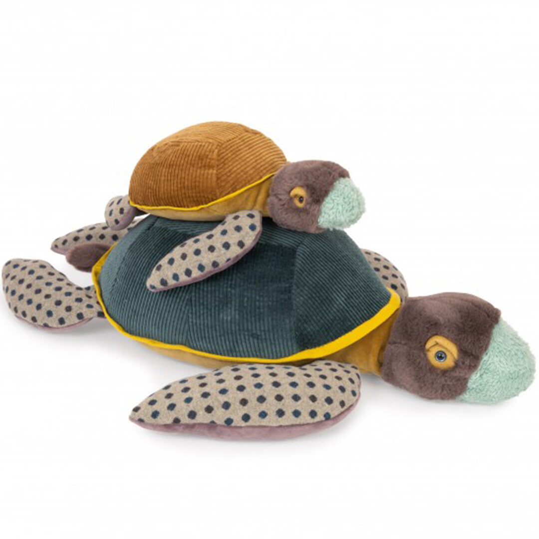 Twee Moulin Roty pluchen schildpadden, een kleine bruine op een grote donkergroene, schuin van voren gefotografeerd.