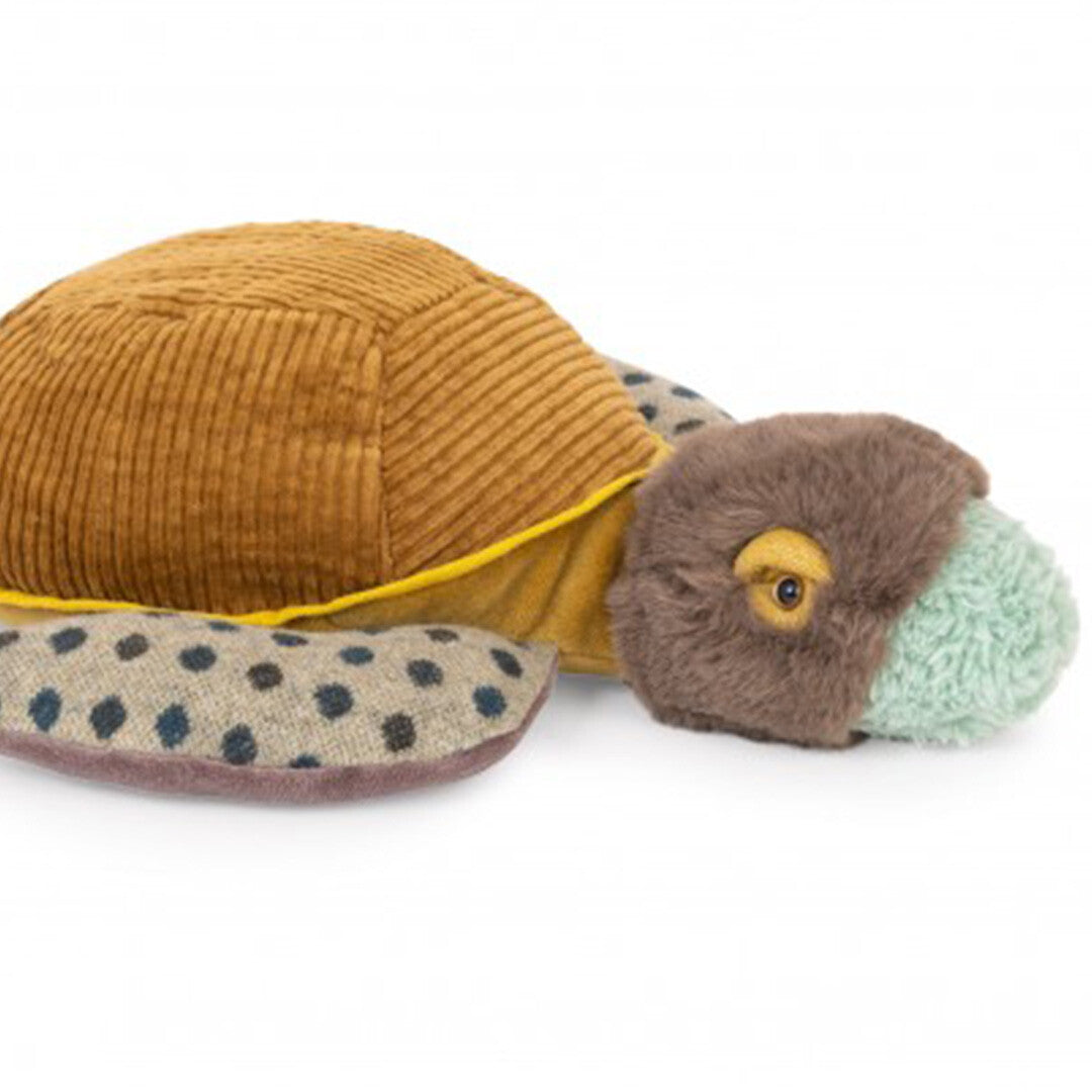 Detailopname van de kop en voorste flippers van de Moulin Roty pluchen schildpad met bruin corduroy schild.