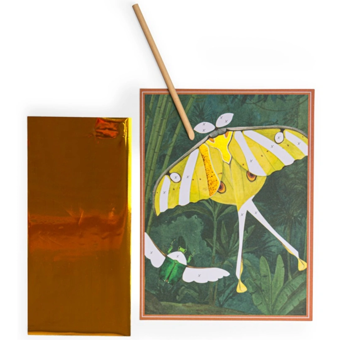 Een knutselkaart met een gele mot, een gouden transferfolievel en een houten stokje.