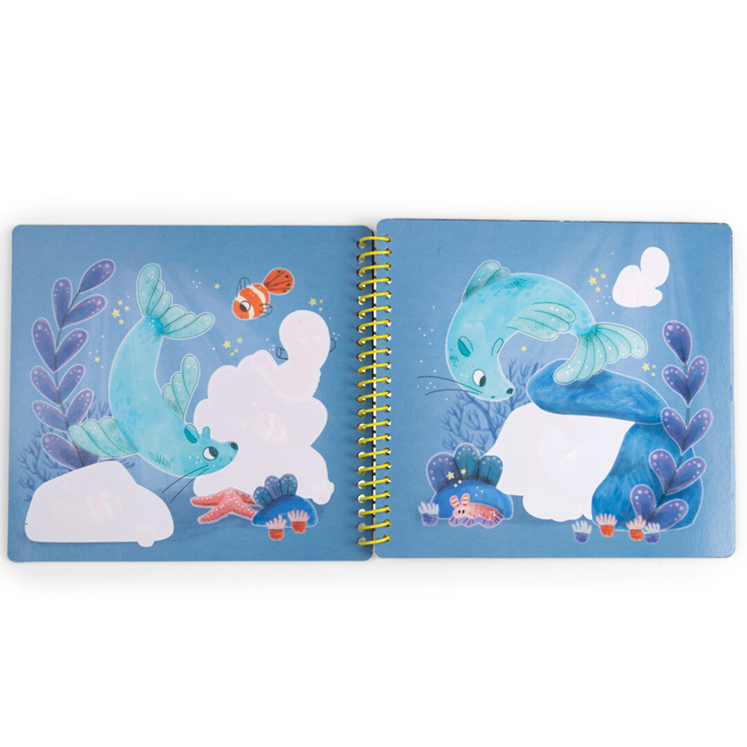 Open magisch schilderboek met twee pagina's die zeehonden en vissen in een onderwaterlandschap tonen, met witte vlakken om in te kleuren.