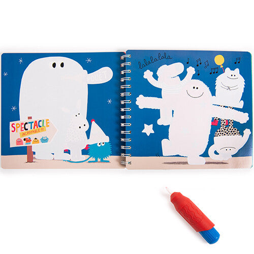Open Moulin Roty magisch kleurboek met witte monsterfiguren op blauwe pagina's en een rode magische pen.