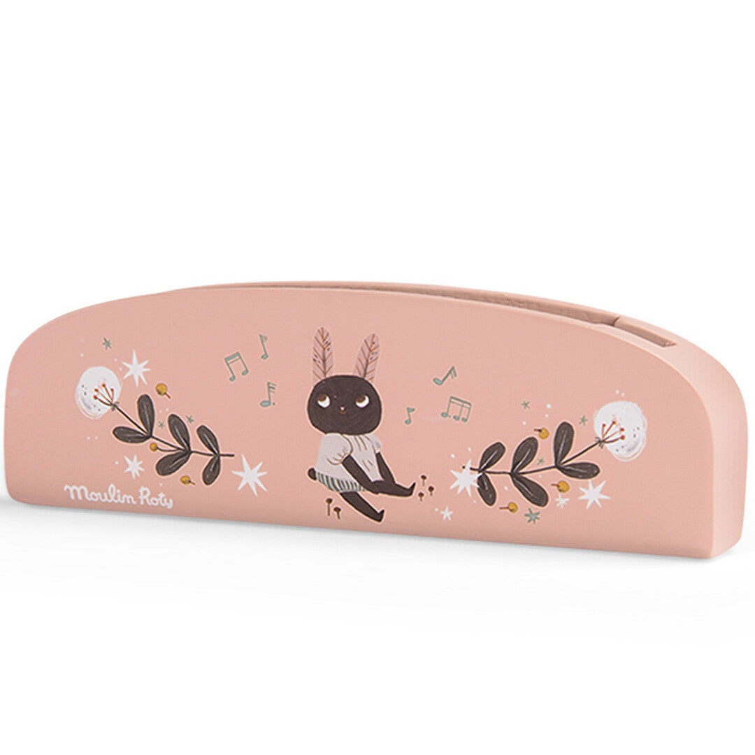 Moulin Roty houten mondharmonica met roze achterkant en illustratie van een konijnfiguur met bloemen en muzieknoten.