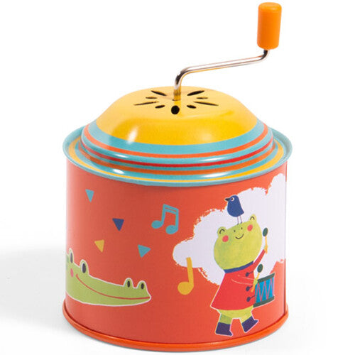 Moulin Roty muziekspeeldoos met een oranje basis, een kikker die drumt en een krokodil.