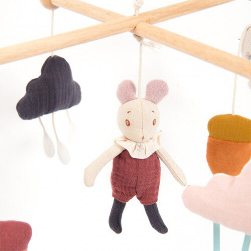 Detail van de Moulin Roty babymobiel met een houten arm, een zwart stoffen wolkje en een stoffen konijnfiguur.