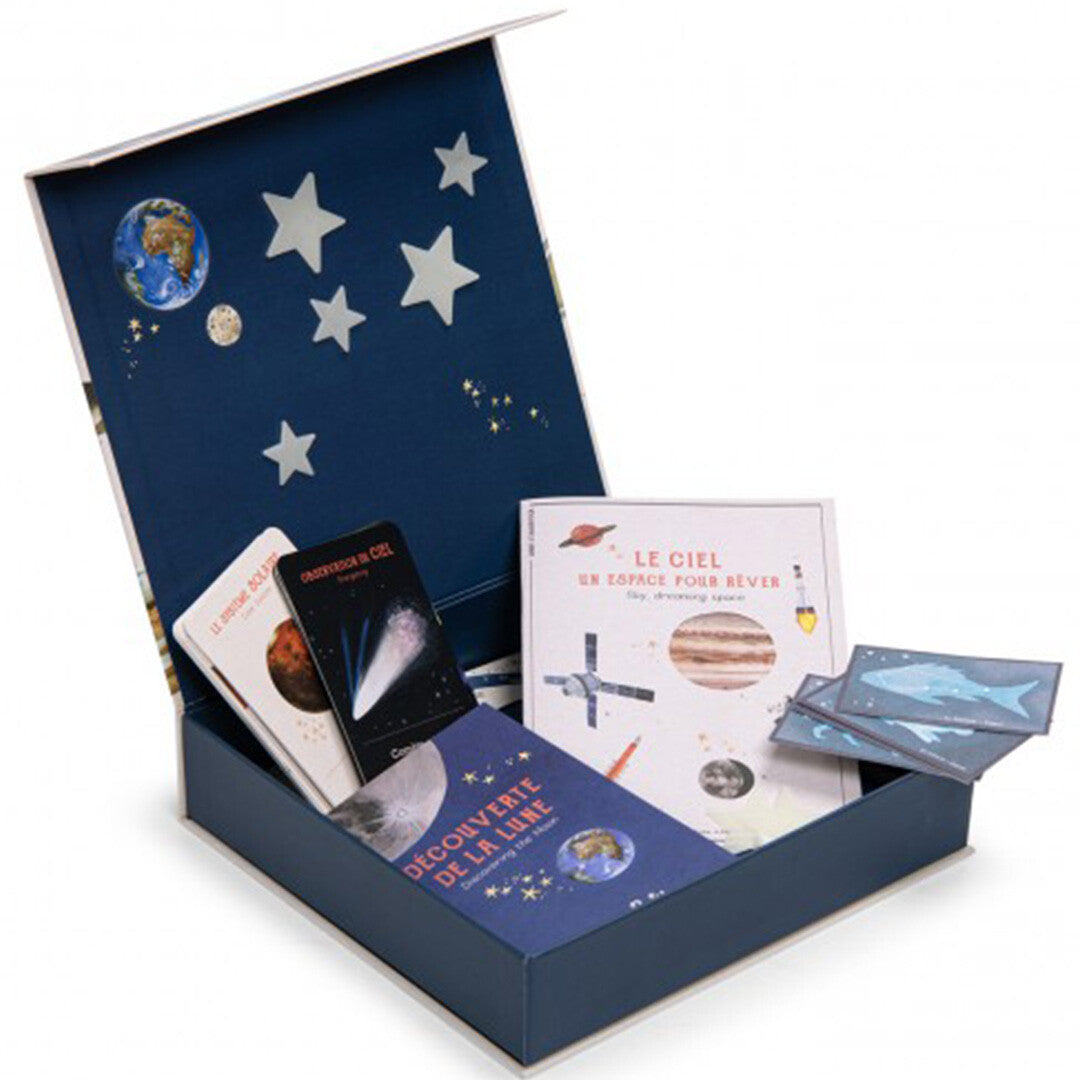 Moulin Roty educatieve ontdekkingsset astronomie in een open doos met kaarten en boekjes over de ruimte.