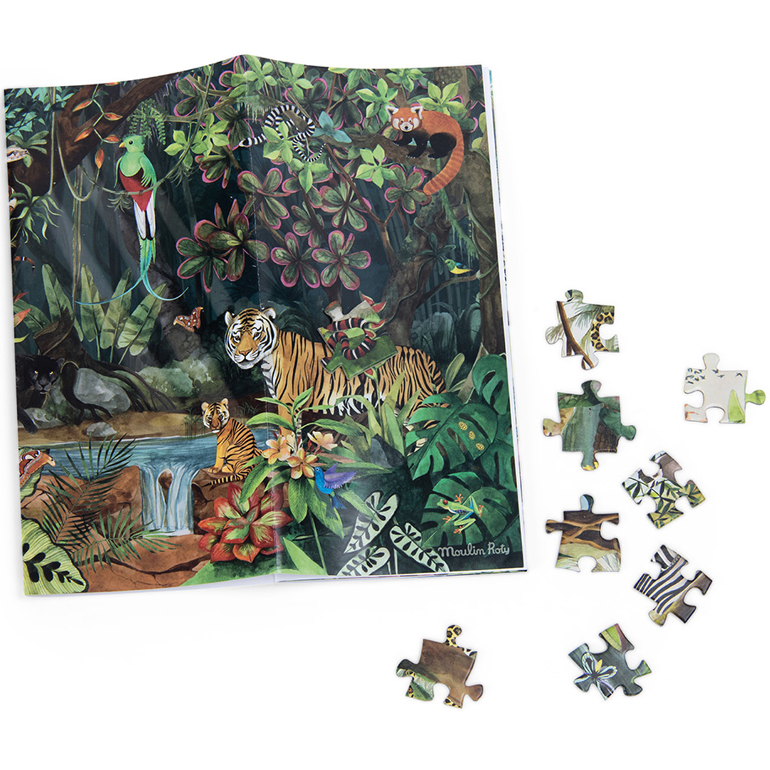 Een opengevouwen Moulin Roty legpuzzelposter met een regenwoudtafereel en losse puzzelstukjes ernaast.