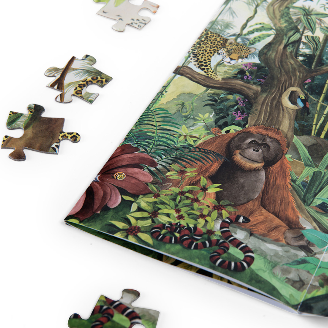 Detail van een legpuzzelposter met een orang-oetan, een luipaard en een slang in een regenwoudomgeving, met enkele losse puzzelstukjes.