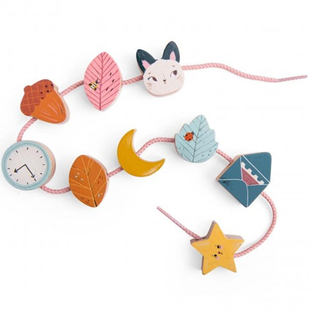 Moulin Roty houten rijgkralen voor peuters met diverse figuren zoals een kat, bladeren, een maan en een ster aan een roze koord.