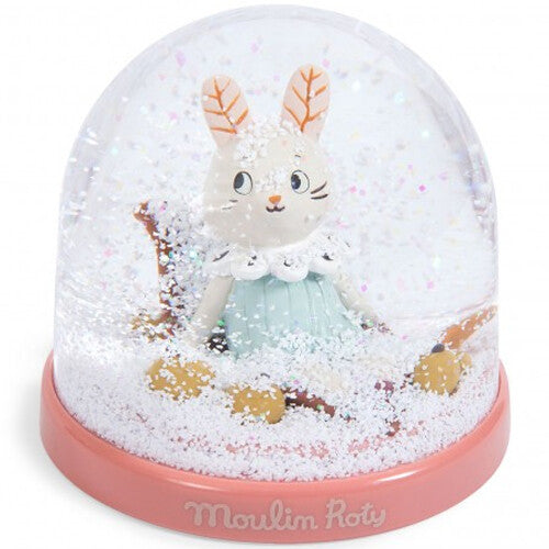 Moulin Roty sneeuwbol met een konijnfiguur, bedekt met witte sneeuw op de roze basis.