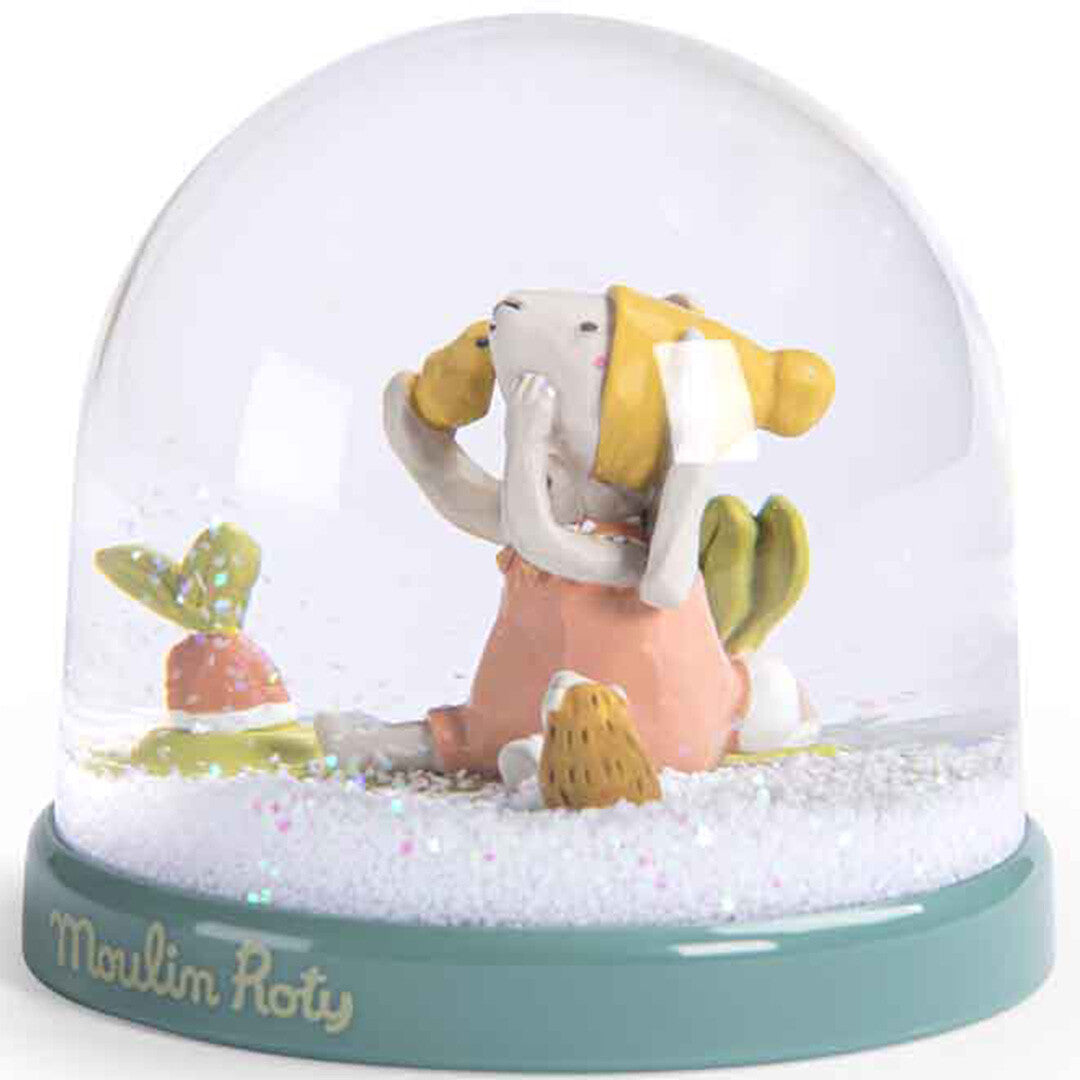 Moulin Roty sneeuwbol met een konijntje, een vogel op zijn schouder, een egel en een wortel, gezien vanaf de zijkant.