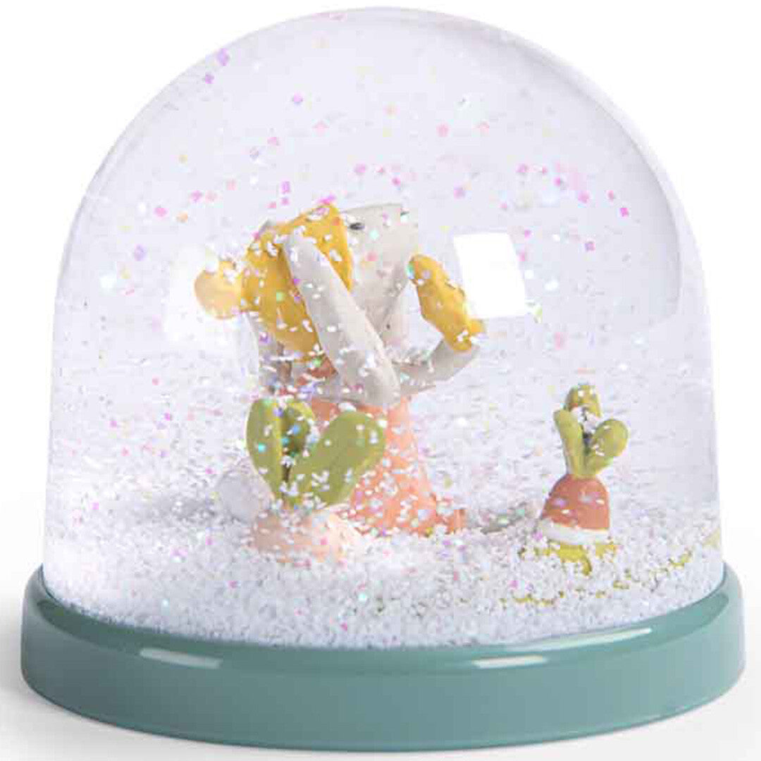 Moulin Roty sneeuwbol met een konijntje, een vogel op zijn schouder en een wortel, met glitter op de bodem.