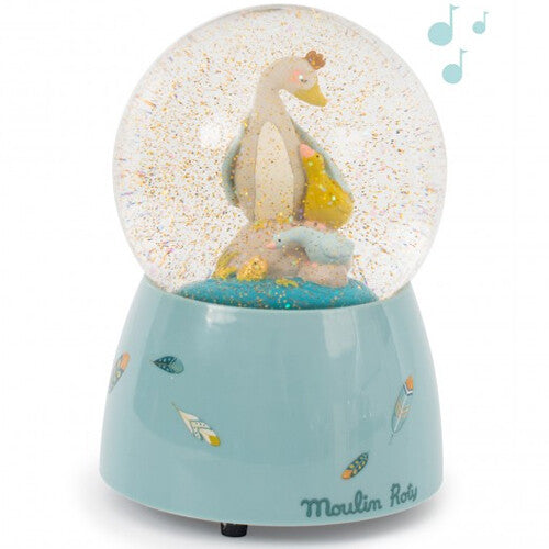 Moulin Roty sneeuwbol met muziek, met een gans en twee kuikens binnenin, en muzieknoten erboven.