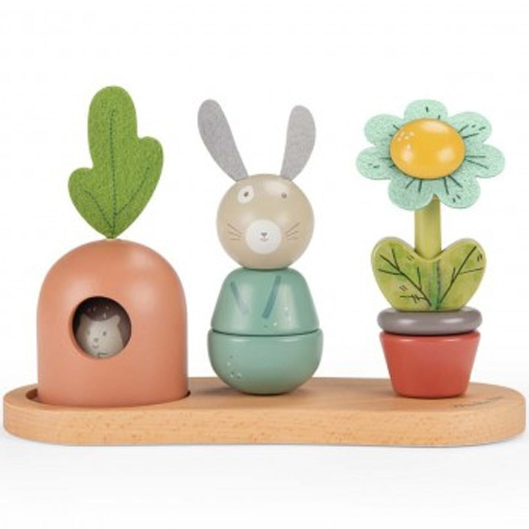 Moulin Roty babyspeelgoed met een wortel, konijn en bloem stapeltoren op een houten basis.