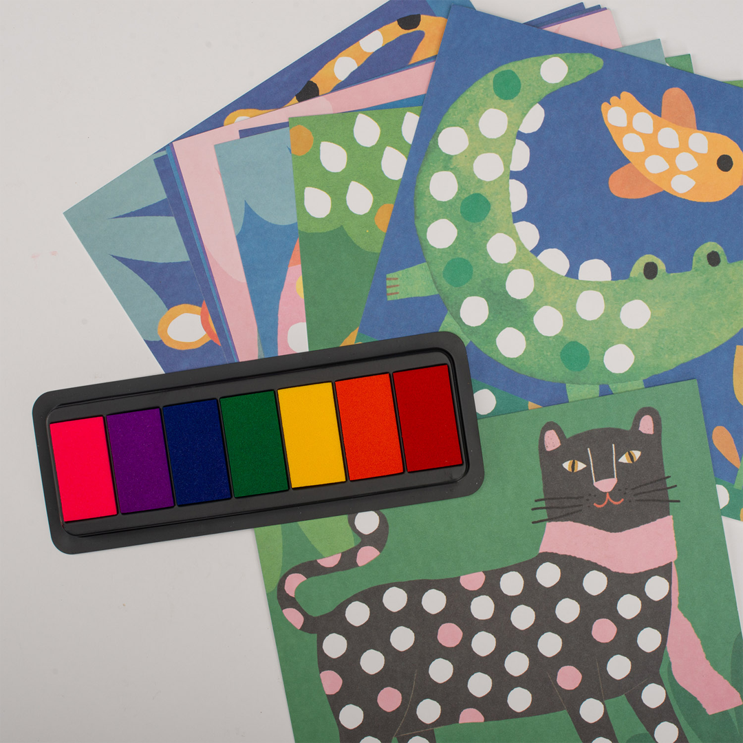 Bovenaanzicht van de Moulin Roty vingerstempelset met een regenboogkleurige inktpad en kaarten met dieren zoals een luipaard en krokodil.