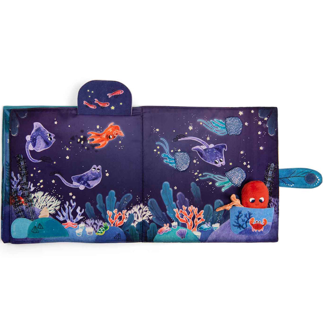 Open stoffen babyboekje met een donkere onderwaterwereld, roggen, kwallen en een octopus in een zakje.