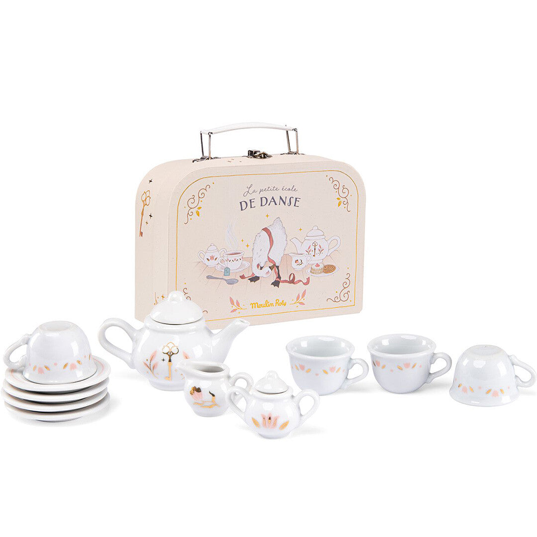 Moulin Roty theeservies met theepot, kopjes en schotels, en een beige koffer met 'La Petite École de Danse' illustraties.