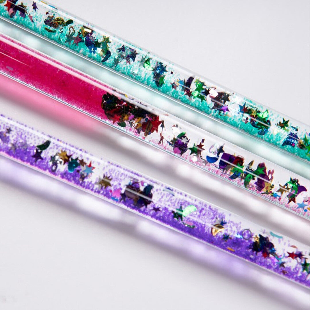 Detailopname van meerdere toverstaven met bewegende glitter, sterren en harten in turquoise, roze en paarse vloeistof.