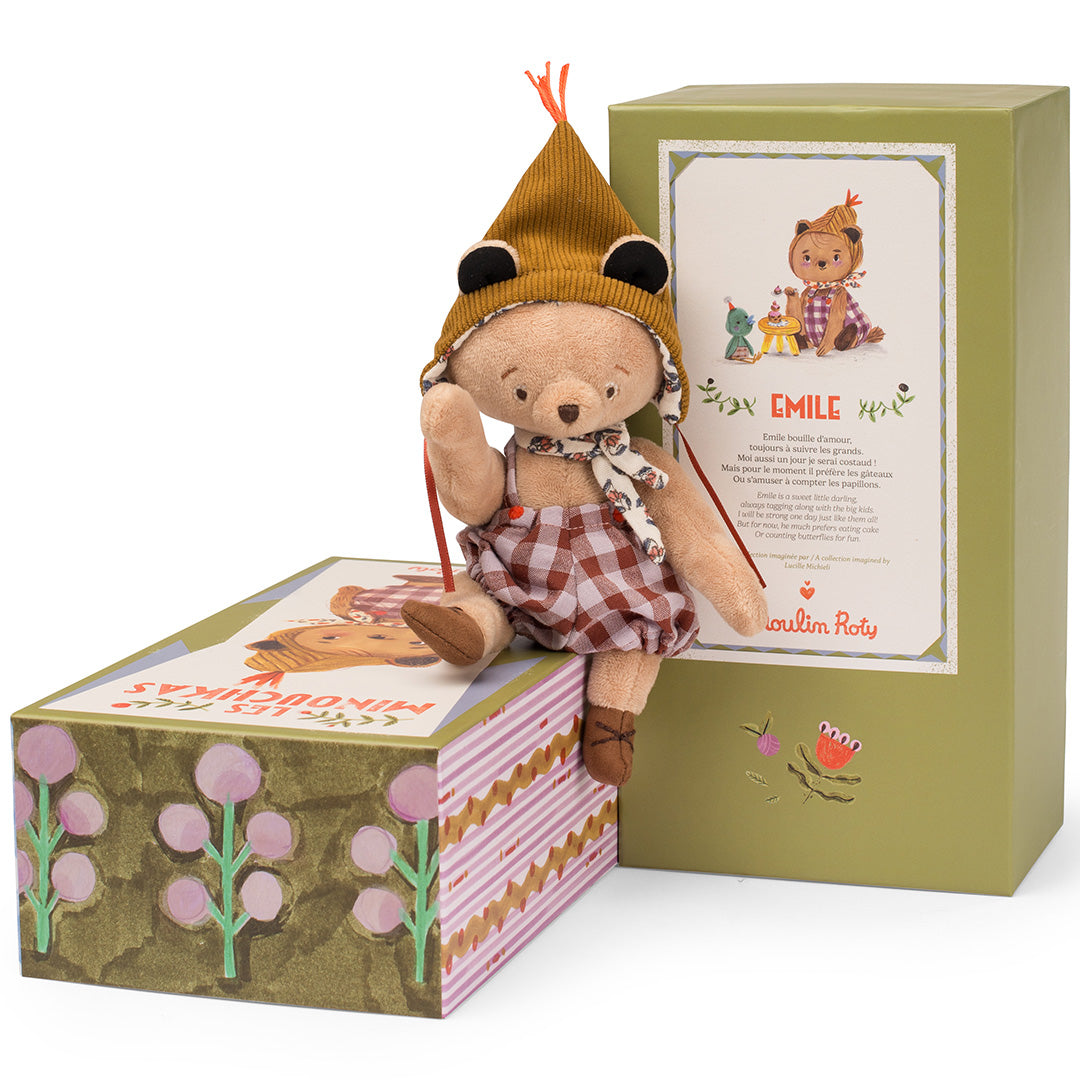 Moulin Roty knuffelbeer Emile zit op zijn versierde verpakking, met de open doos ernaast.