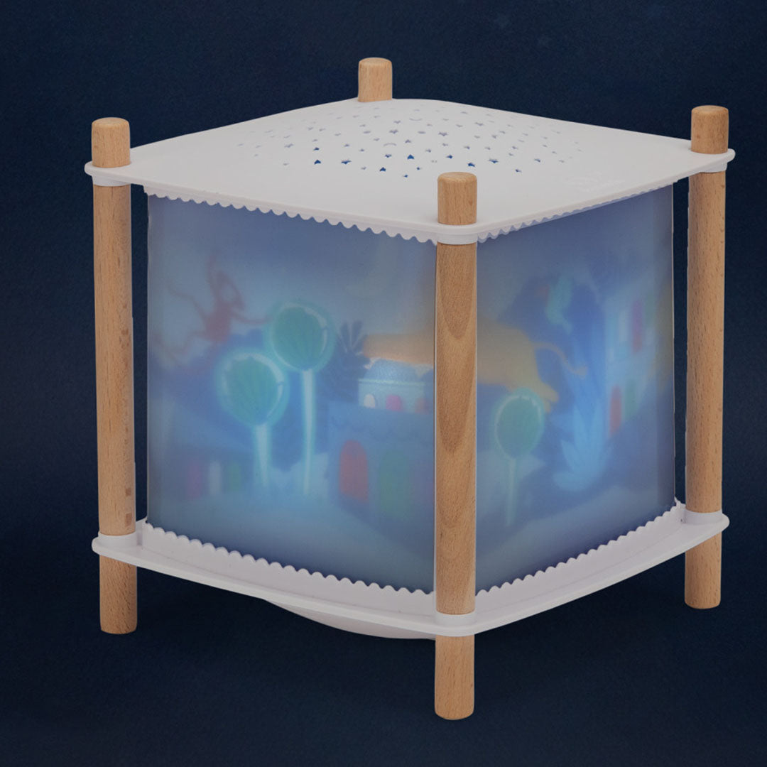 Moulin Roty nachtlampje met houten poten en een projectie van een fantasiewereld op de zijkanten.