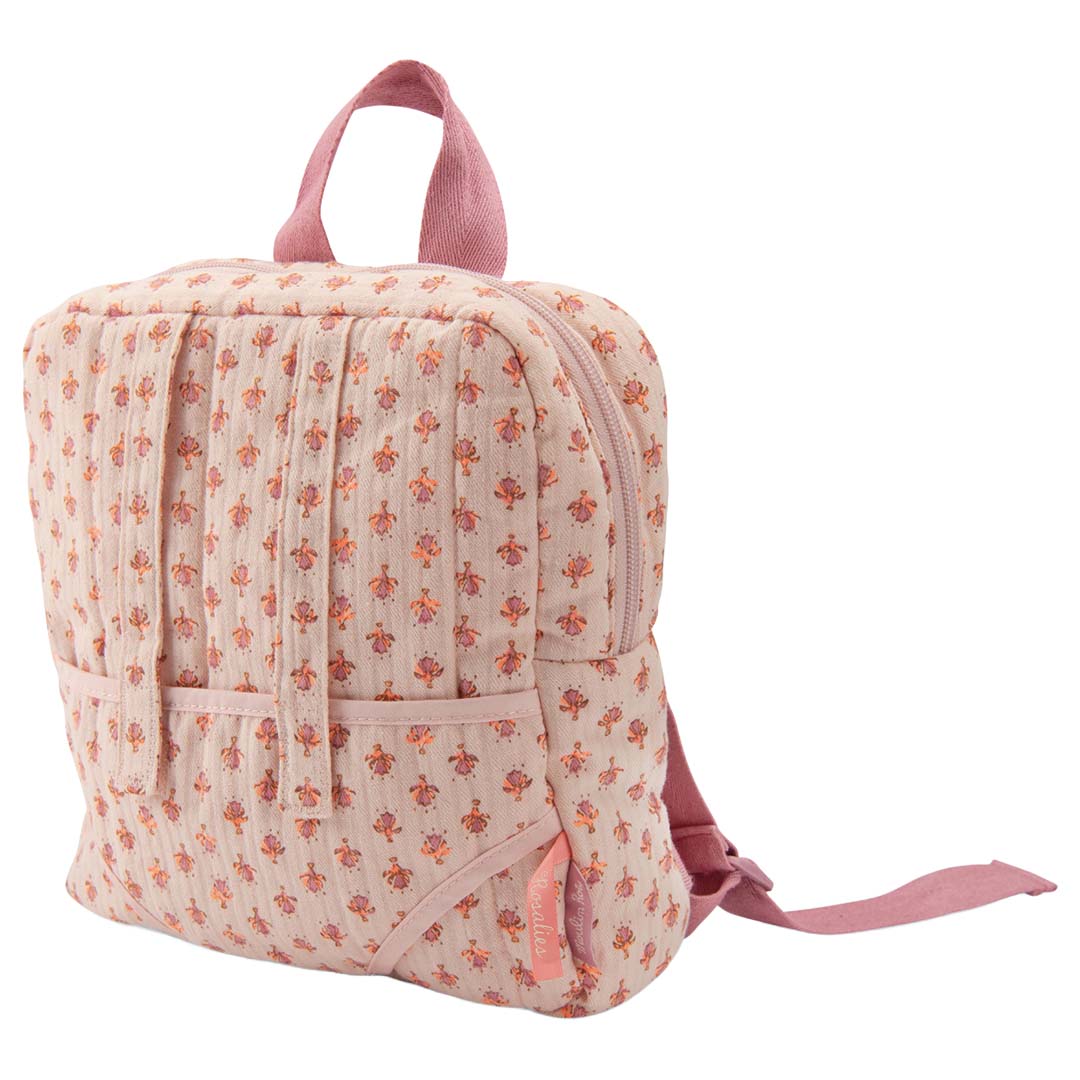 Moulin Roty roze gebloemde poppendraagzak van polyester, schuin van voren gefotografeerd met merklabel.
