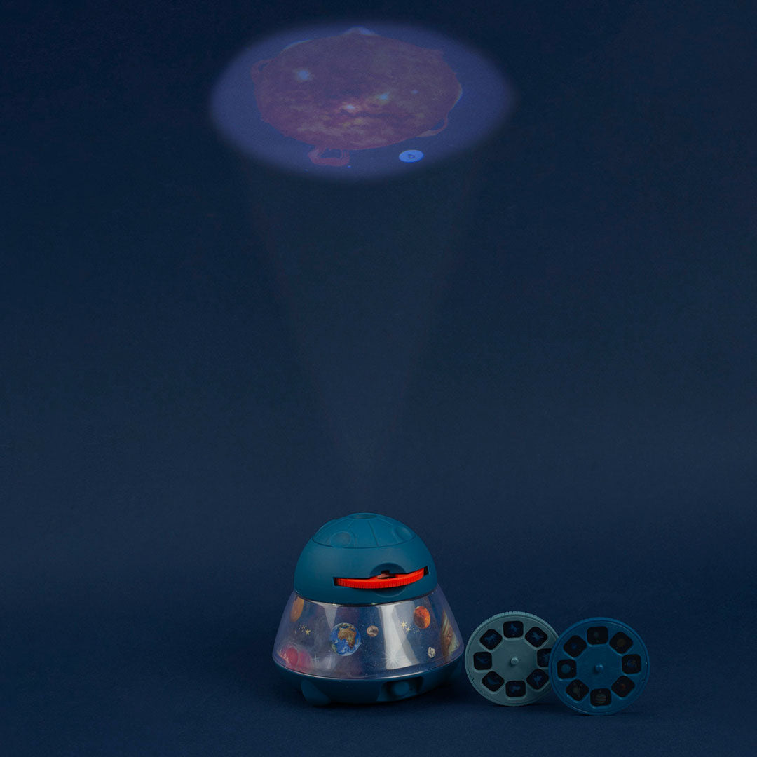 De Moulin Roty ruimteprojector projecteert een afbeelding van een planeet op een donkere muur, met twee projectieschijven ernaast.