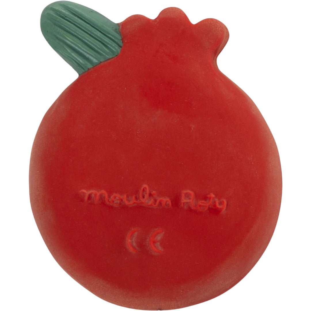 De achterkant van de rode Moulin Roty granaatappel bijtring met groen blad en ingegraveerd merklogo.