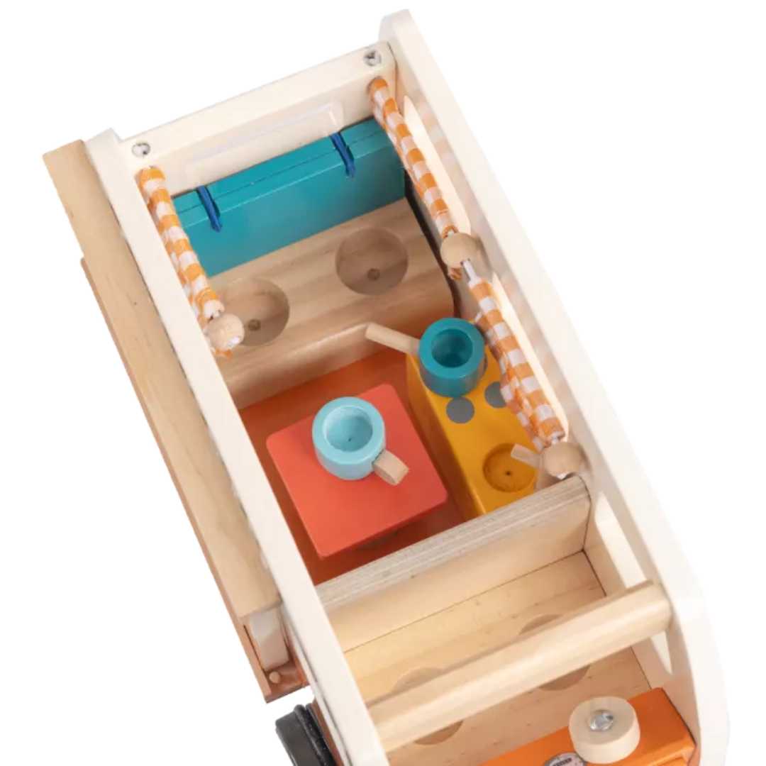 Detail van het interieur van de houten speelgoedcamper met kleine meubels.