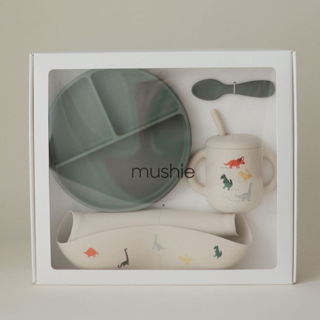 Mushie siliconen voedingsset voor baby's met dinopatroon in een witte geschenkverpakking.