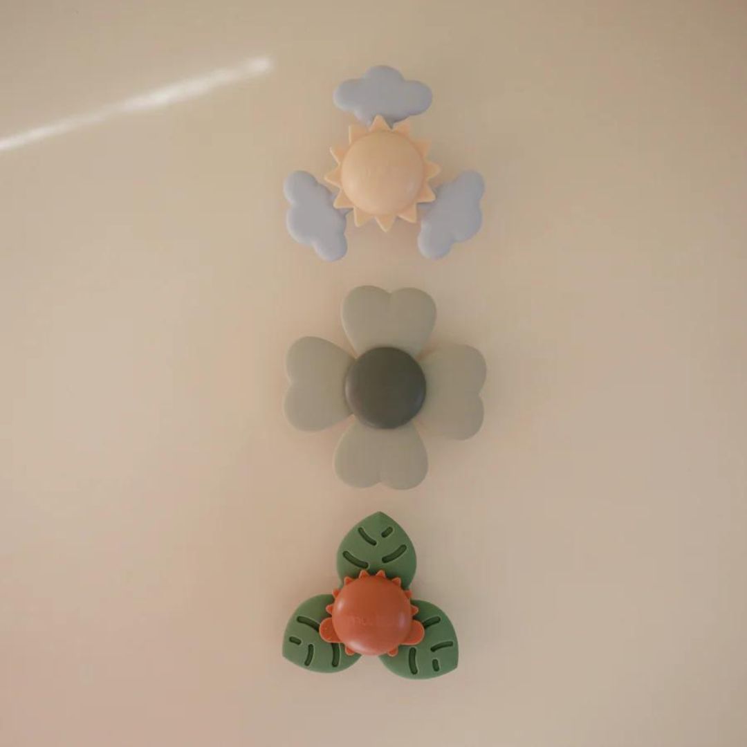 Drie mushie babyspeelgoed spinners met zuignap in verschillende vormen: zon, bloem en blad.