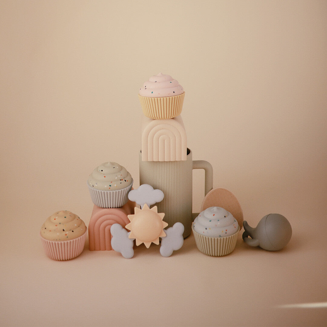 Collectie mushie siliconen babyspeelgoed met onder andere een zon- en wolken spinner, regenboog stapelaars en cupcake speelgoed.
