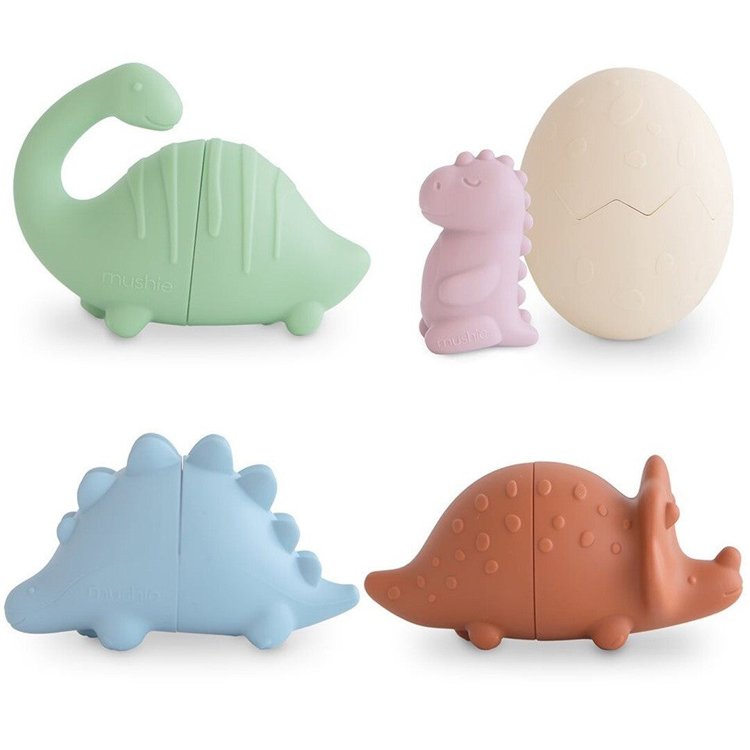 Vier mushie siliconen dinosaurus badspeeltjes in verschillende kleuren, inclusief een ei.