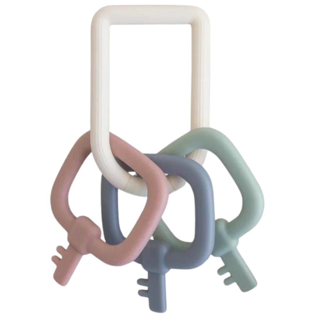 Mushie siliconen bijtring sleutelbos met een witte ring en roze, blauwe en groene sleutels.