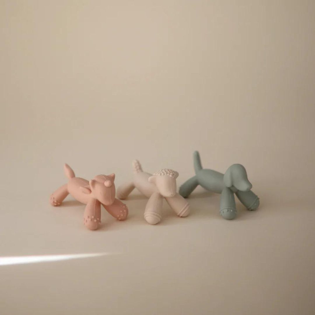 Drie Mushie bijtspeeltjes in de vorm van een roze eenhoorn, lichtroze schaap en lichtblauw hondje.
