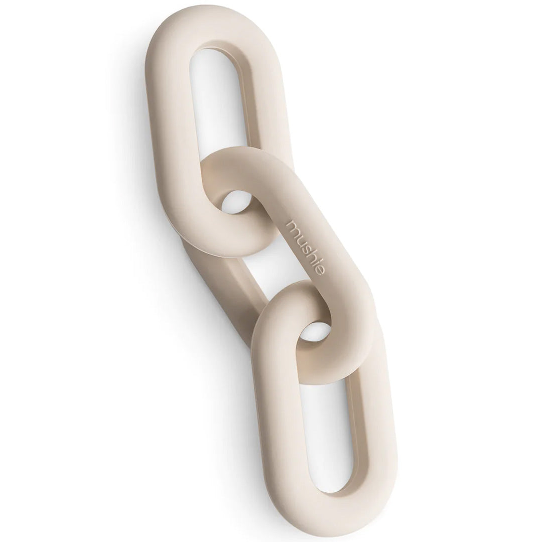 Mushie bijtspeelgoed van twee in elkaar grijpende beige siliconen schakels.