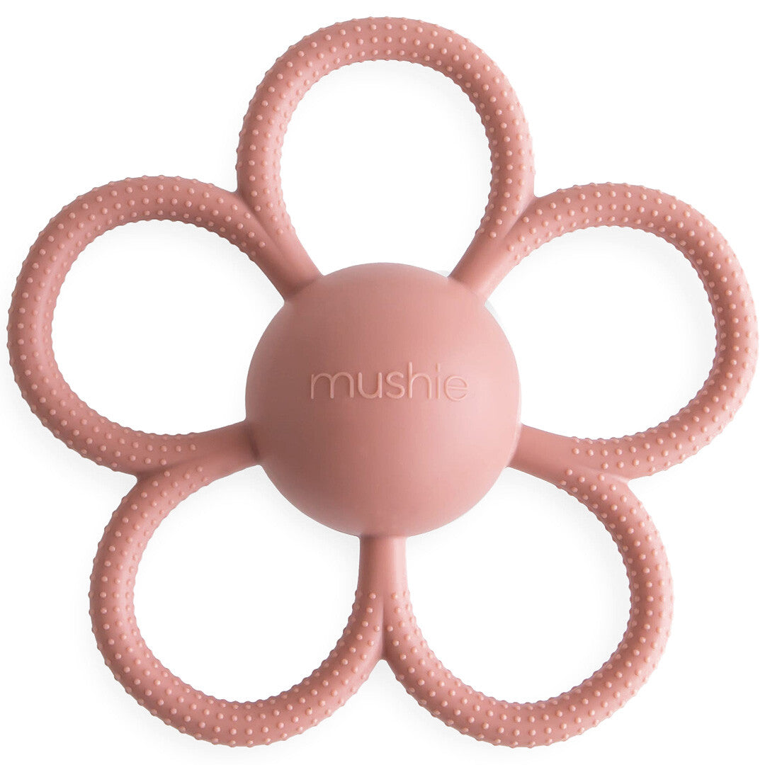 Mushie roze siliconen bijtspeelgoed in de vorm van een bloem met getextureerde oppervlakken.