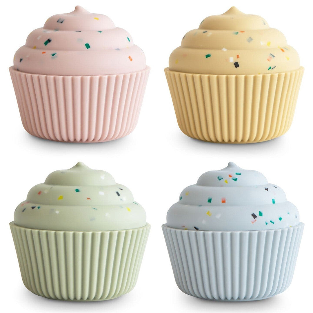 Vier mushie siliconen speelgoedcupcakes in pastelkleuren met kleurrijke stippen.