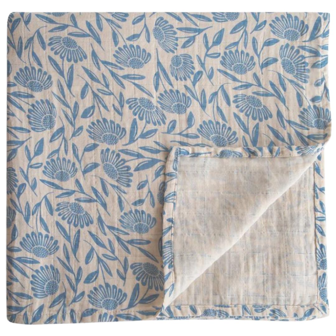 Gevouwen mushie inbakerdoek met blauw bloemenpatroon.