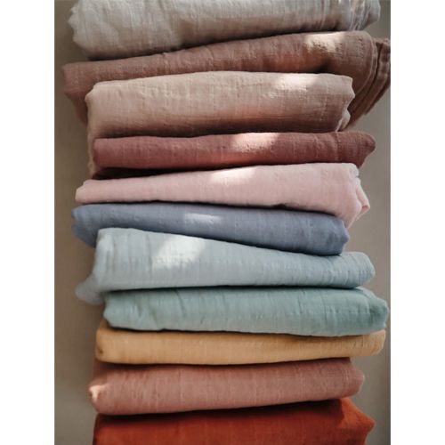 Stapel van mushie inbakerdoeken voor baby's in verschillende kleuren.