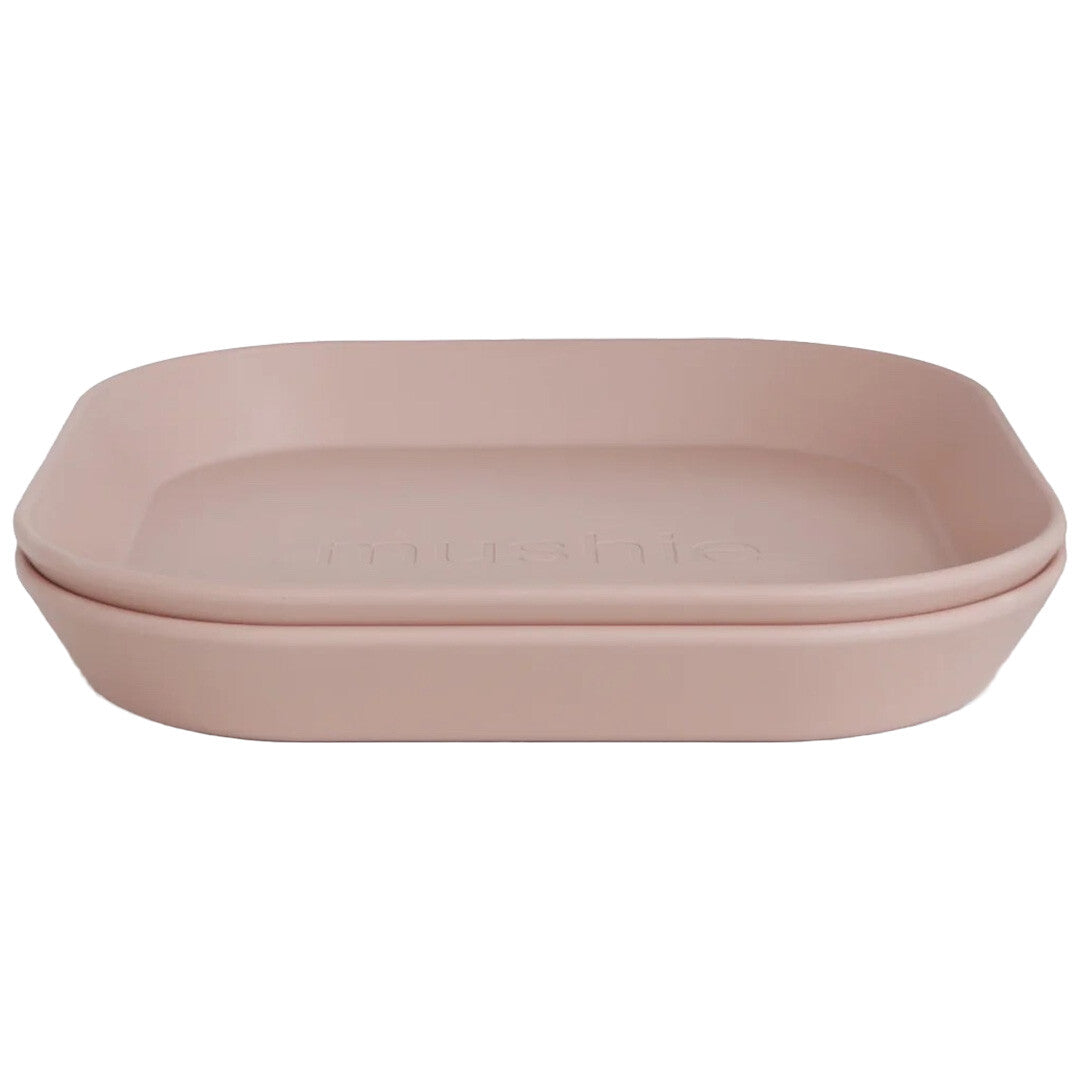 Twee gestapelde mushie kinderborden in blush roze, met het logo zichtbaar.