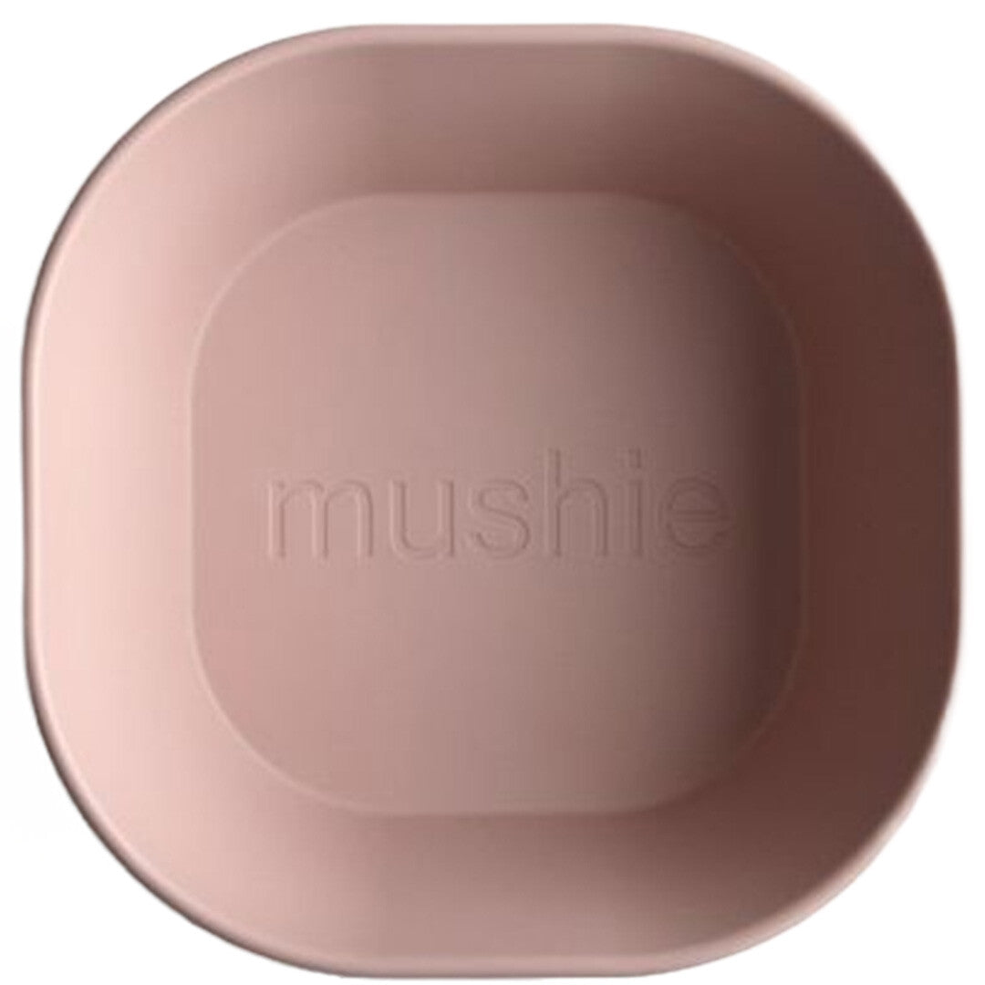 Bovenaanzicht van een roze Mushie kinderkom met het merklogo in de bodem.
