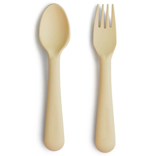 mushie kinderlepel en -vork in beige kleur op een witte achtergrond.