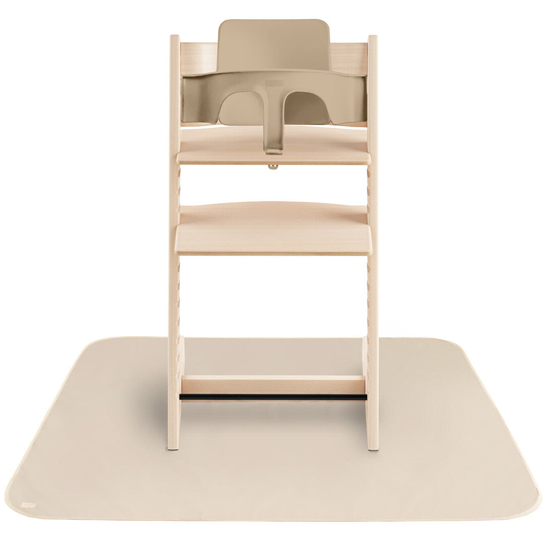 Beige mushie knoeimat onder een houten kinderstoel met beige babyzitje.