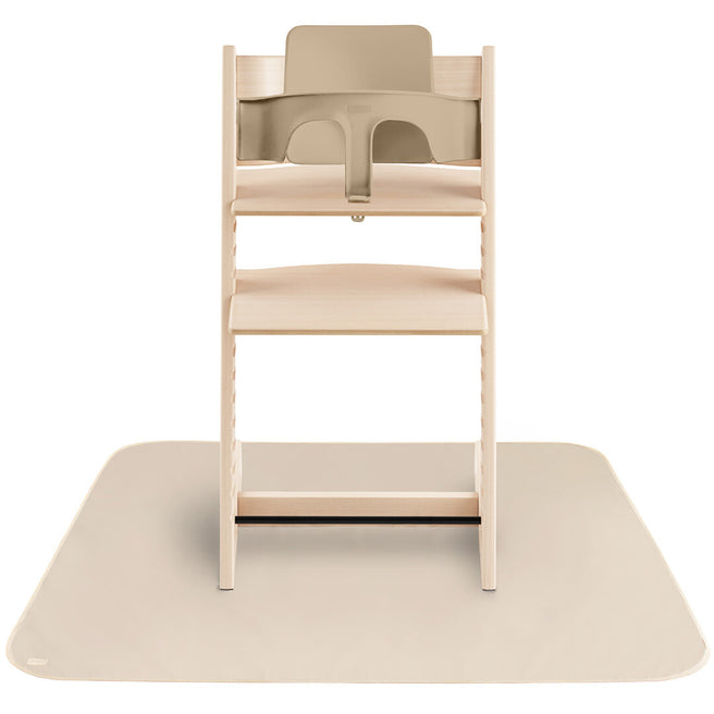 Beige mushie knoeimat onder een houten kinderstoel met beige babyzitje.