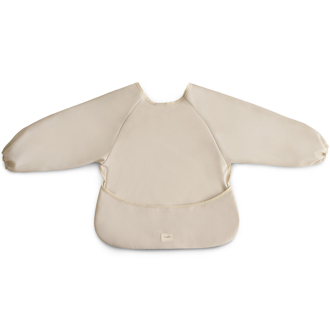 Mushie beige mouwslab voor baby's, plat gefotografeerd op een witte achtergrond.