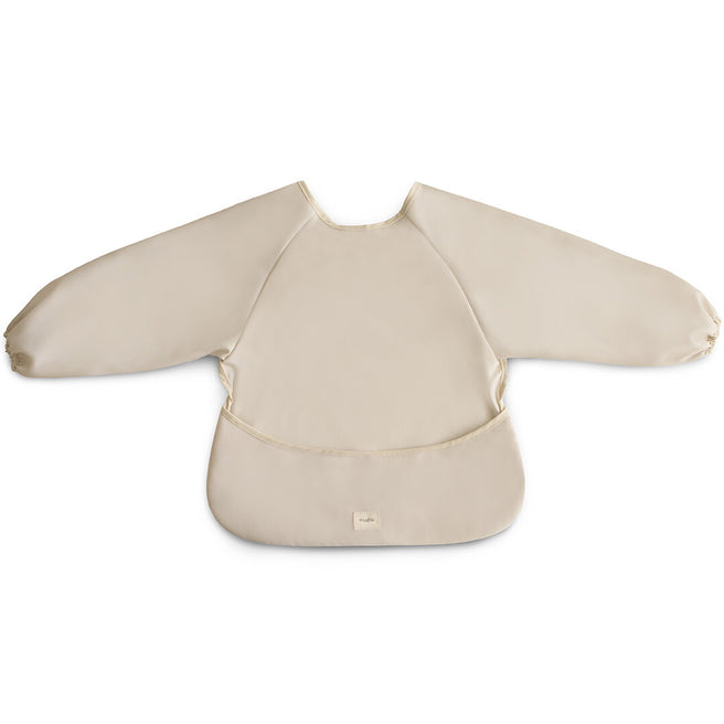 Mushie beige mouwslab voor baby's, plat gefotografeerd op een witte achtergrond.