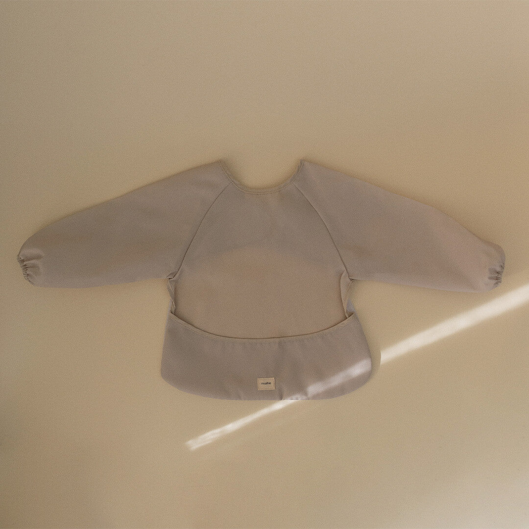 Mushie mouwslab in de kleur fog, plat gefotografeerd van bovenaf op een lichte ondergrond.